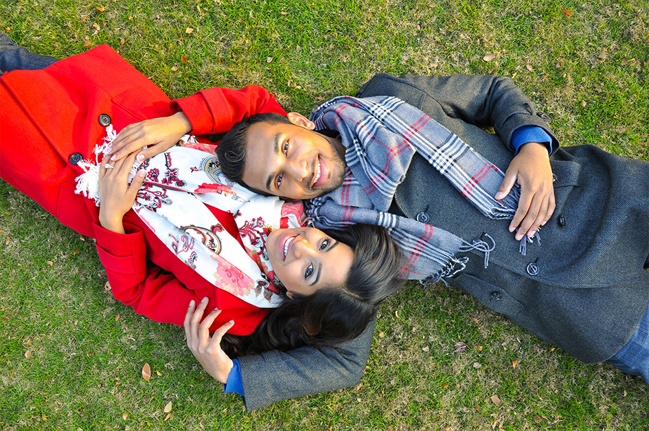 Engaged Couple laying on grass